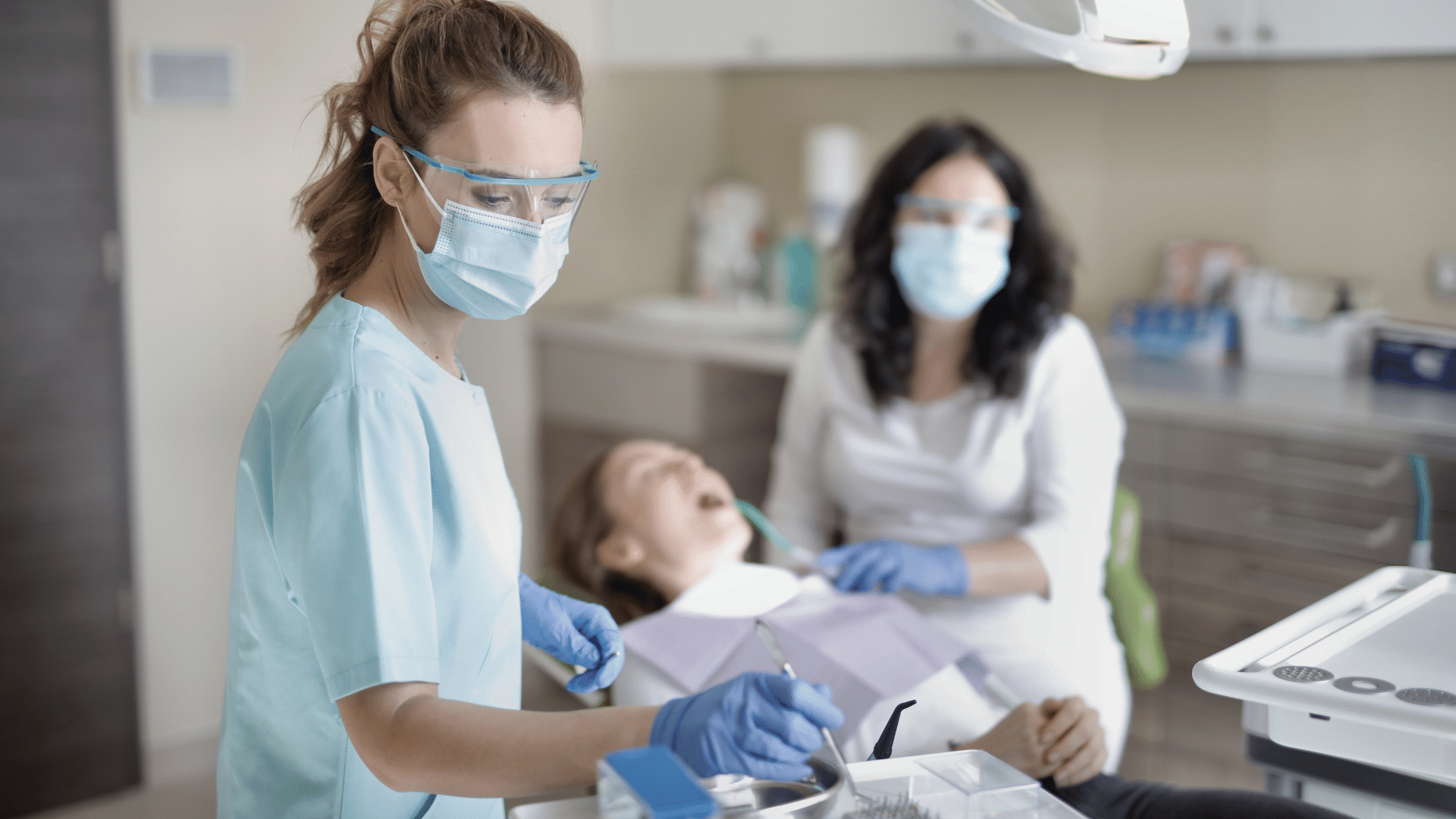 a female dental assistant and dentist treat a patient