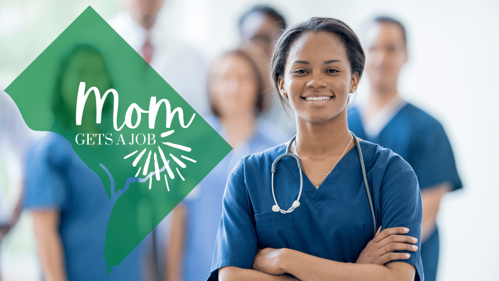 Black female dental assistant in DC wears blue scrubs and a stethoscope while smiling at the camera with a group of other people in scrubs behind her